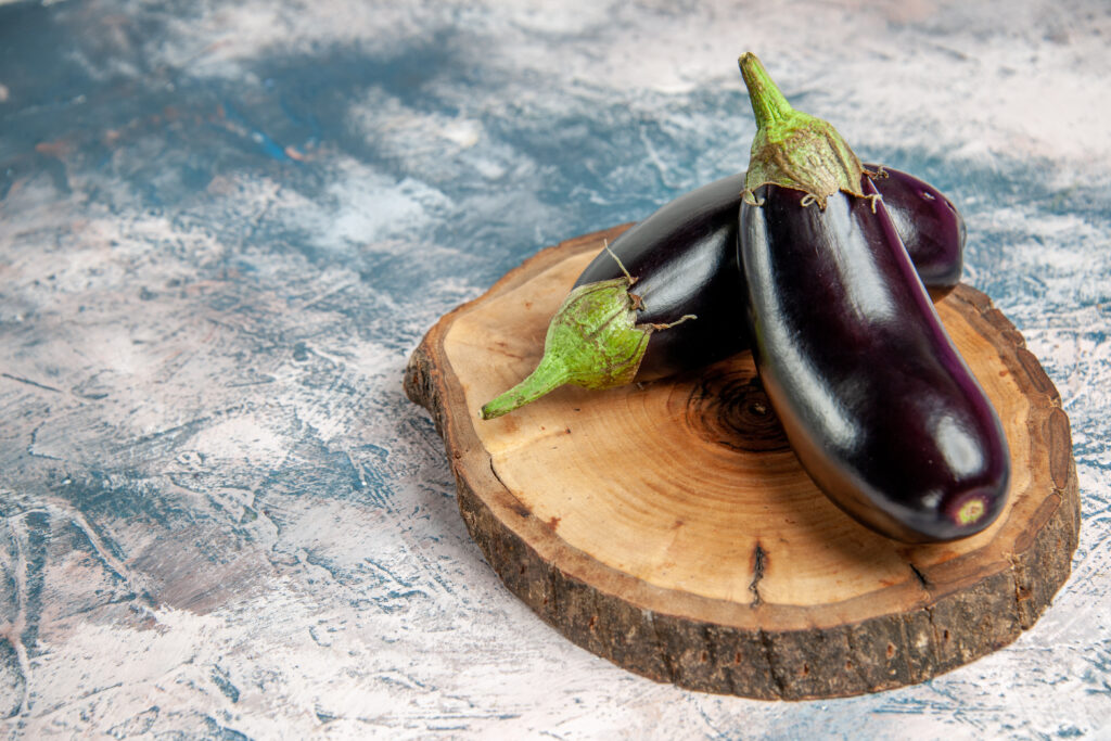 aubergine - <a href="https://www.freepik.com/free-photo/front-view-aubergines-tree-wood-board-blue-white-free-place_15916003.htm#query=Aubergine&position=0&from_view=search&track=sph">Image by KamranAydinov</a> on Freepik