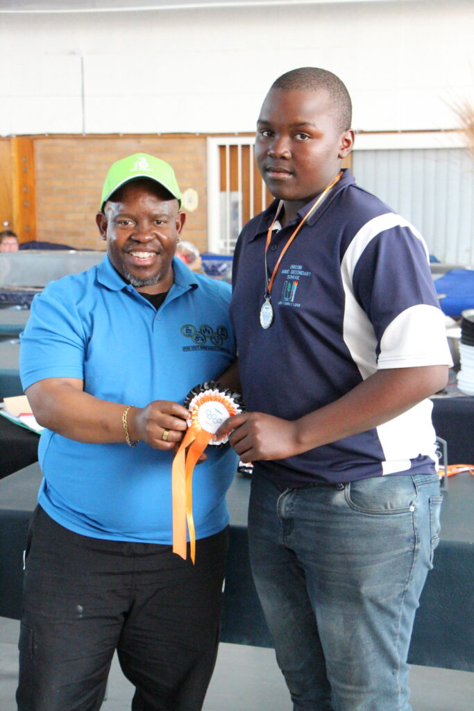 Mr Lehentse Seekoei, CES Free State Education Department, award 
Elias Matshiwa with his first place in youth show catagory.